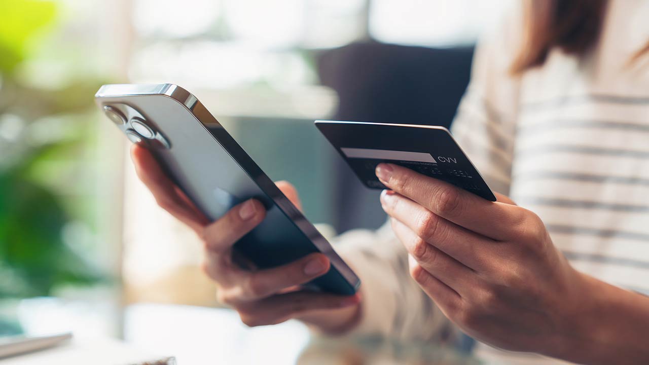 Woman hand holding credit cards and using smartphone for shopping online with payment on internet banking