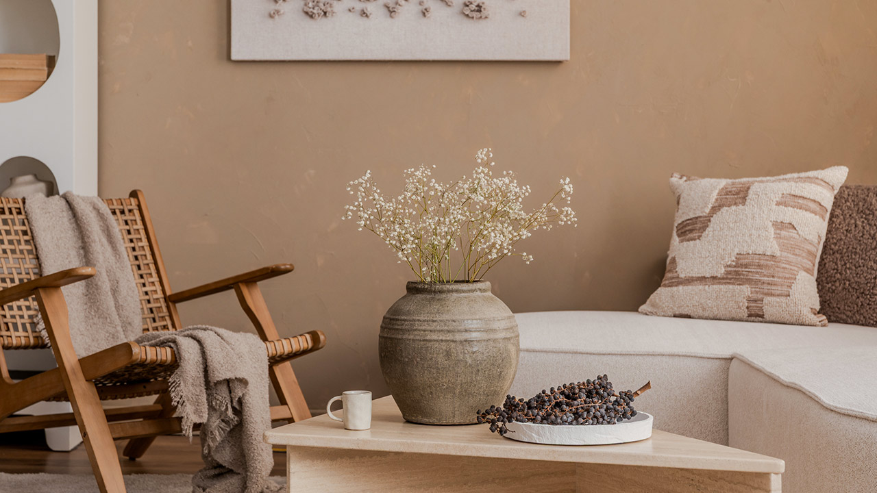 Natural-toned interior with rustic vase, textured pillows, and cozy lounge chair in a calm neutral setting stock photo